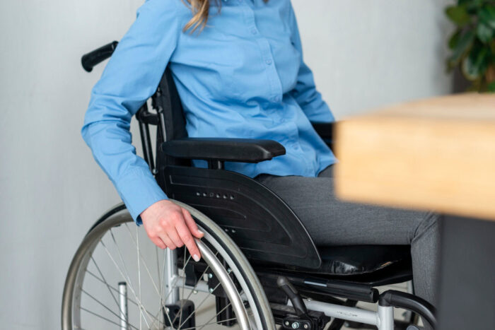 Mujer intentando mejorar postura en silla de ruedas